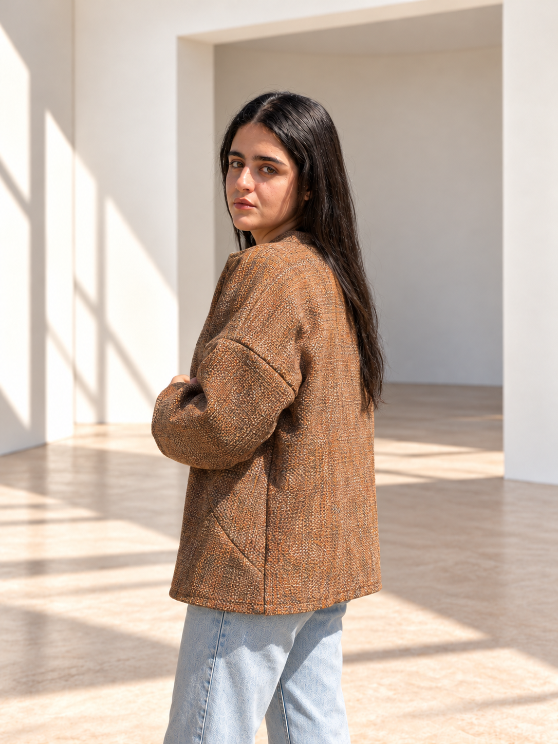 Three-quarter side view of Fine R Studio copper tweed jacket showing its rust, brown and cream flecked weave.