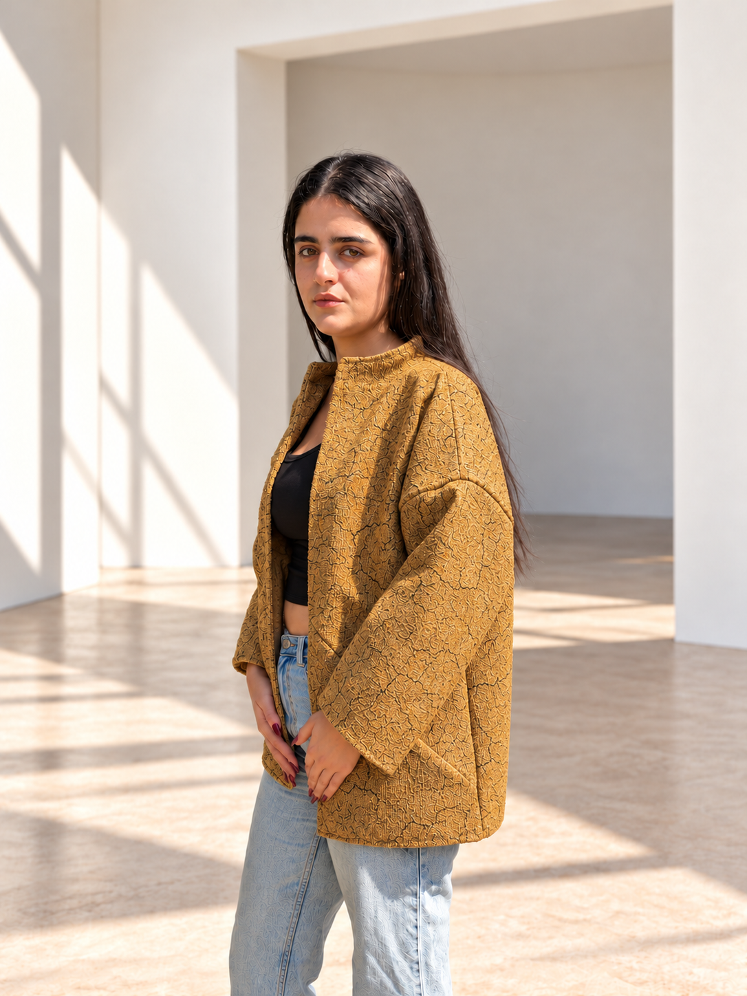 Front three-quarter view of Fine R Studio mustard textured jacket with an open front and wide sleeves.
