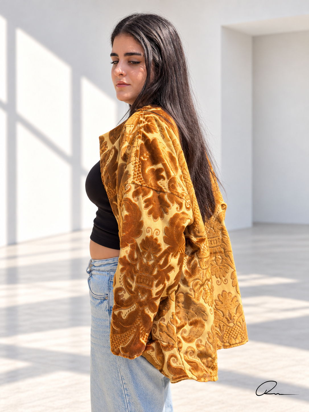Side view of Fine R Studio gold floral velvet jacket showing textured damask motifs and wide sleeves.