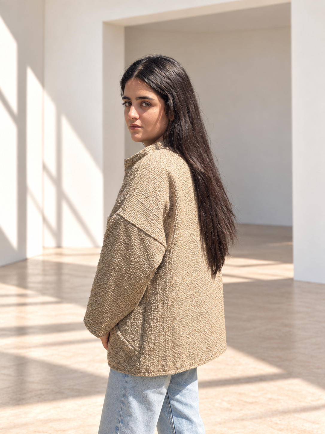 Back view of Fine R Studio beige bouclé jacket showing its relaxed cut and textured surface.