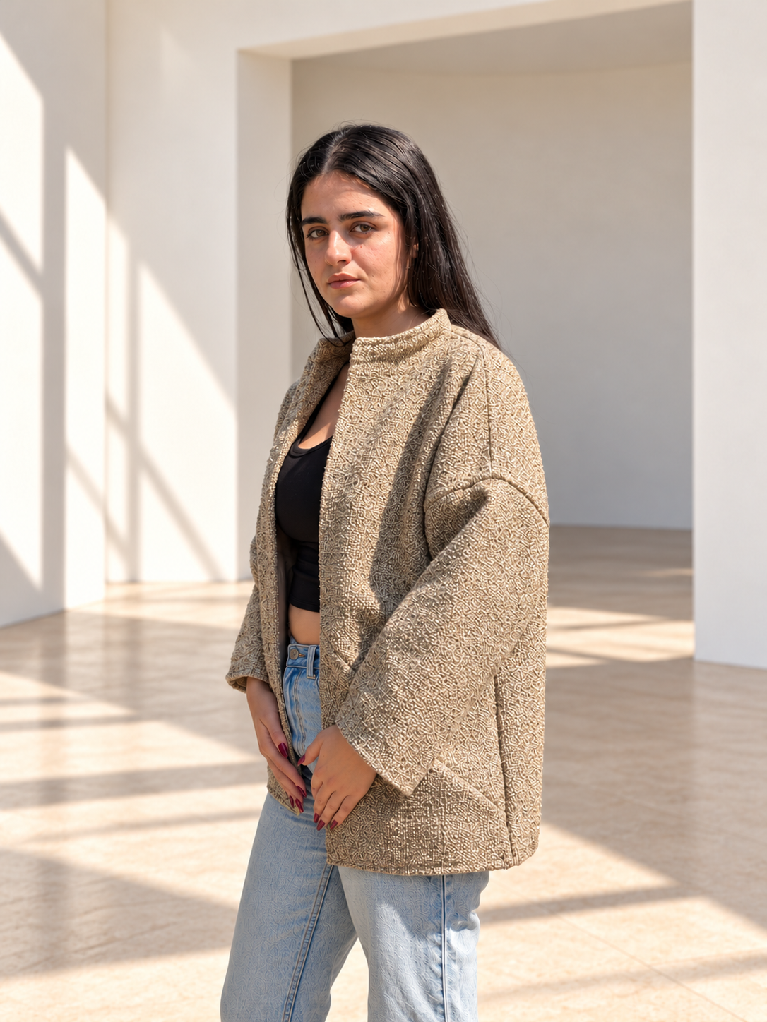 Three-quarter view of Fine R Studio beige bouclé jacket showing its cream and sand textured fabric.