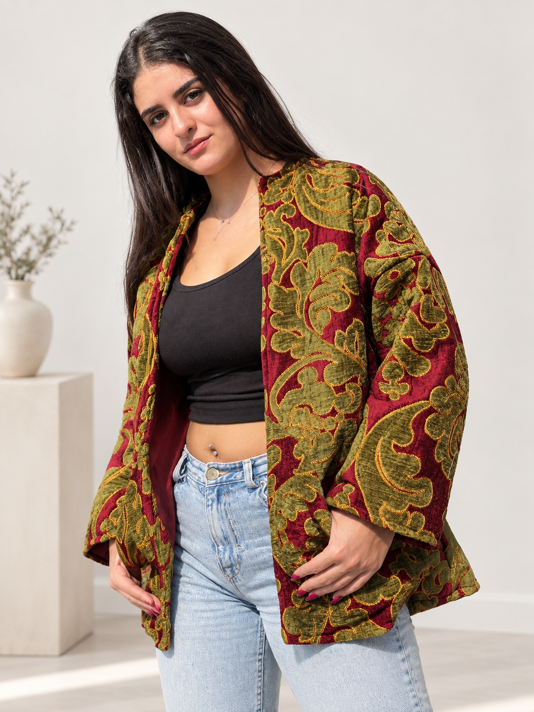 Three-quarter front view of Fine R Studio burgundy velvet jacket with olive botanical motifs and gold outlines.