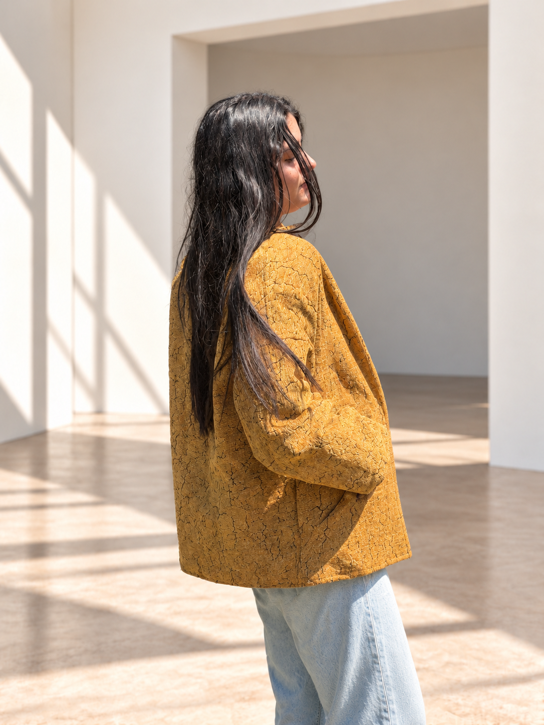 Back view of Fine R Studio mustard jacket showing its intricate tonal texture and relaxed silhouette.