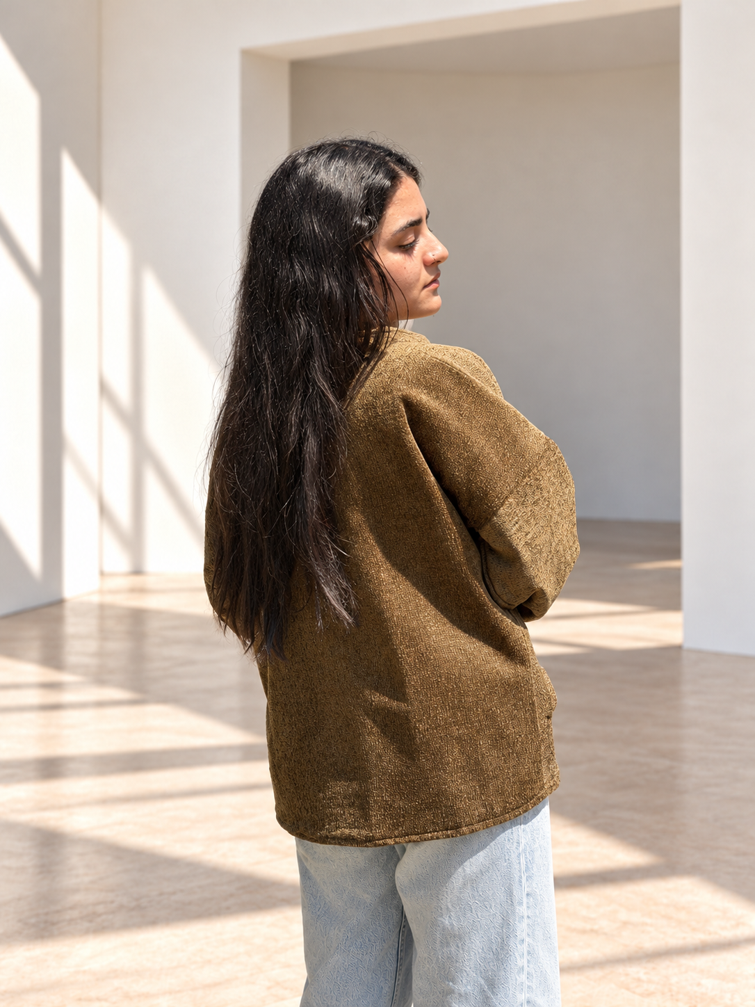 Back view of Fine R Studio olive textured jacket showing its generous sleeves and relaxed silhouette.