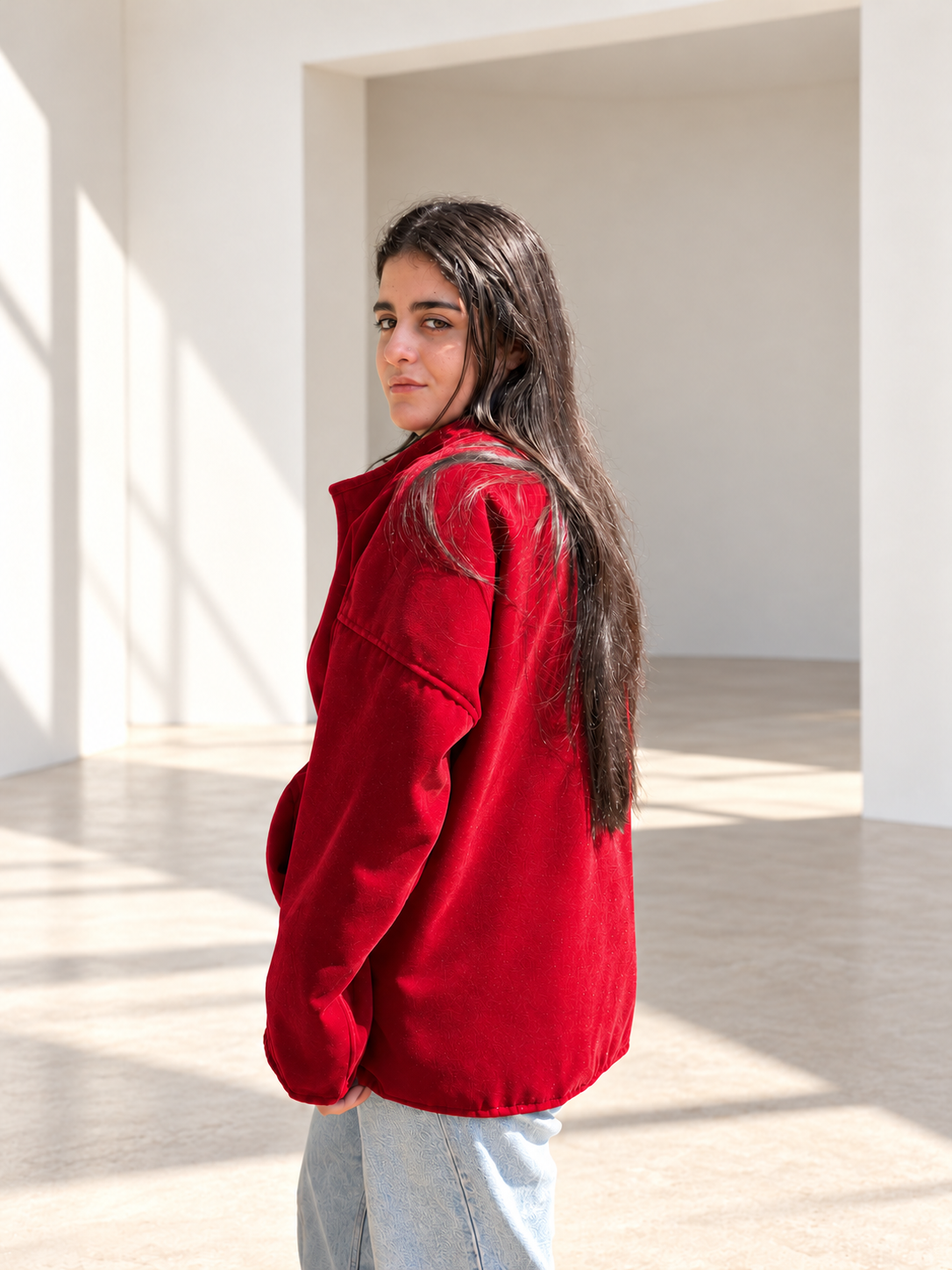 Rear three-quarter view of Fine R Studio red velvet jacket showing the relaxed cut and dropped shoulders.