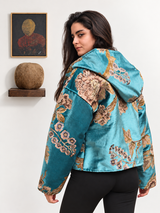 Back view of Fine R Studio turquoise floral hooded jacket with gold and brown motifs